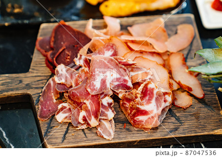 meat cuts on a wooden cutting board. dried delicacy meat.  87047536