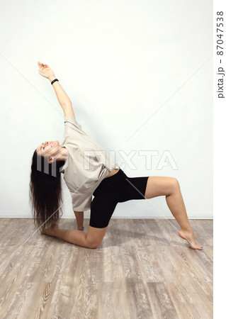 Fitness, pilates, sports, gymnastics, exercise, healthy lifestyle concept. An attractive woman does exercises in the gym. Front view. Vertical photo. 87047538