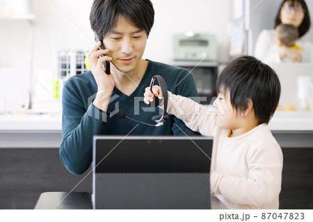 子供にテレワークの邪魔をされるアジア人男性 87047823
