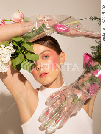 European woman with pastel flowers isolated on light beige European woman with pastel flowers isolated on light beige 87049958