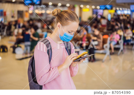 Woman traveler with medical face mask to protection the coronavirus in airport Woman traveler with medical face mask to protection the coronavirus in airport 87054390