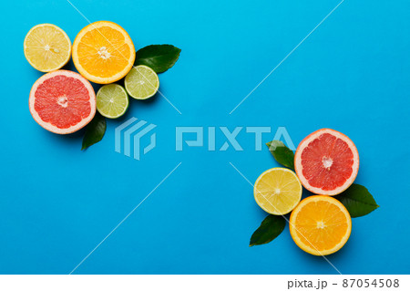 Fruit background. Colorful fresh fruits on colored table. Orange, lemon, grapefruit Space for text healthy concept. Flat lay, top view, copy space 87054508