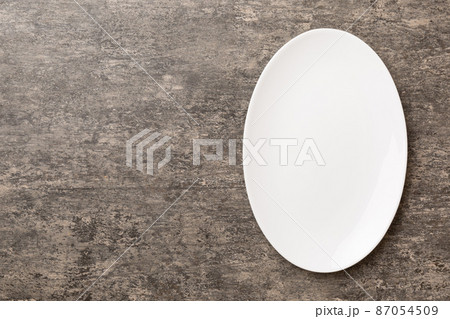 Top view of empty light plate on cement background. Empty space for your design 87054509