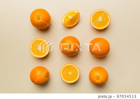 Fruit pattern of fresh orange slices on colored background. Top view. Copy Space. creative summer concept. Half of citrus in minimal flat lay 87054513