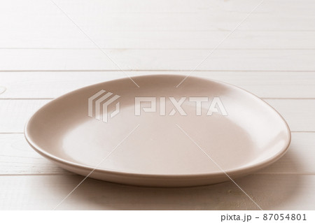 Perspective view of empty pink plate on wooden background. Empty space for your design Perspective view of empty pink plate on wooden background. Empty space for your design 87054801