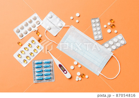 Protective face masks or surgical masks, medicine pills and thermometer on table background. Coronavirus disease. Corona virus concept. Space for text 87054816
