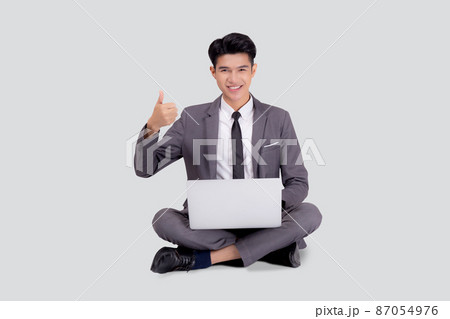 Young asian business man sitting work on laptop computer to internet online isolated. 87054976