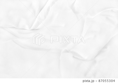 Close up top view of white bedding sheet and wrinkle messy blanket in bedroom after wake up in the morning. 87055304