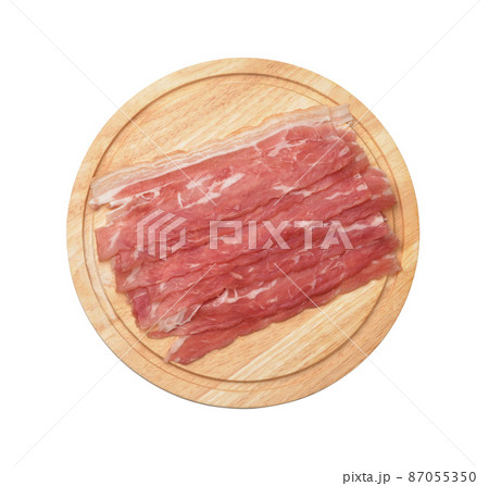 Top view of bacon strips on wooden cutting board Top view of bacon strips on wooden cutting board 87055350