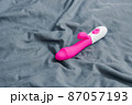 Vibrating sex toy lying on crumpled mattress. 87057193