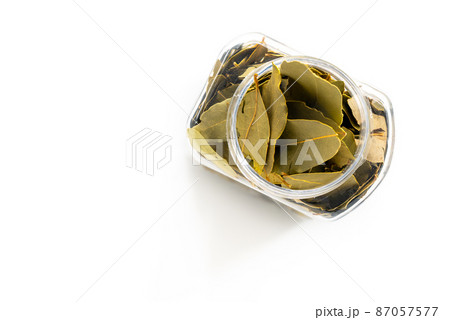 The top view image of organic Bay leaves the plastic container, flat lay design with blank space for text. Close up dried Bay leaves in a cleared plastic packaging. 87057577