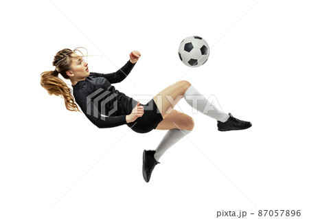 Leg kick. One sportive girl, female soccer player training with football ball isolated on white studio background. Sport, action, motion, fitness Leg kick. One sportive girl, female soccer player training with football ball isolated on white studio background. Sport, action, motion, fitness 87057896