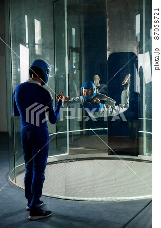 A man trains a woman as an astronaut. Classes on flying in a wind tunnel. 87058721