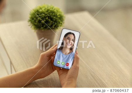 Distance Communication. Female with smartphone making video call to her friend 87060437