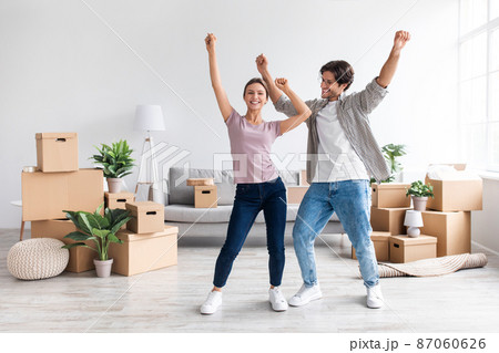 Happy glad millennial european lady and guy in casual dancing, enjoy relocation in room Happy glad millennial european lady and guy in casual dancing, enjoy relocation in room 87060626