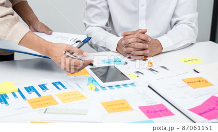 Businesswoman holding document and pointing data on tablet to explaining business report to executive 87061151