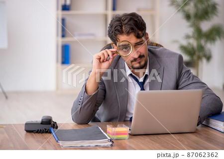 Young male employee sitting in the office Young male employee sitting in the office 87062362