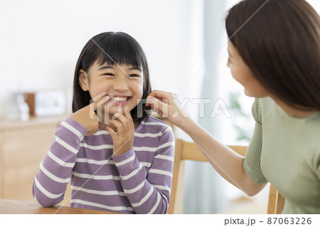 母親に歯を見せる女の子 87063226