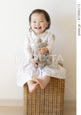 ぬいぐるみを抱っこしてご機嫌な幼児 87066171
