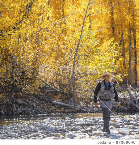 USA, Idaho, Bellevue, Senior fisherman wading in Big Wood River in Autumn 87069040