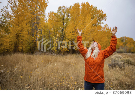 USA, Idaho, Bellevue, Smiling woman with arms raised in grassy meadow in Autumn USA, Idaho, Bellevue, Smiling woman with arms raised in grassy meadow in Autumn 87069098