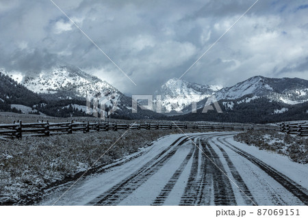 USA, Idaho, Stanley, Road between pastures in snowy mountain landscape 87069151