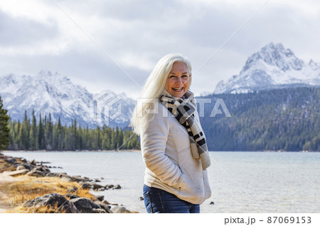 USA, Idaho, Stanley, Portrait of smiling senior woman at mountain lake 87069153