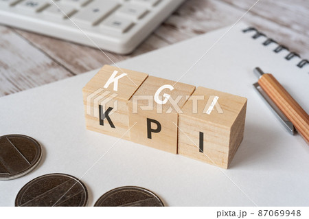 KGIとKPIのイメージ｜「KGI」「KPI」と書かれた積み木、コイン、ノート、電卓、ペン 87069948