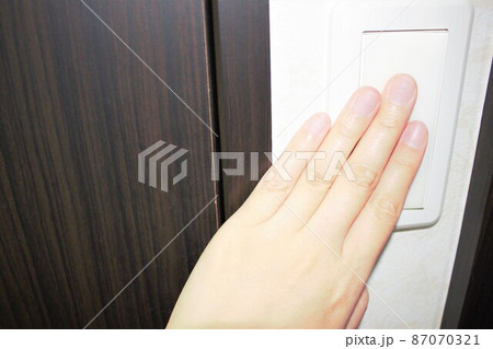 左の手で電源を入れる女性　片手 87070321