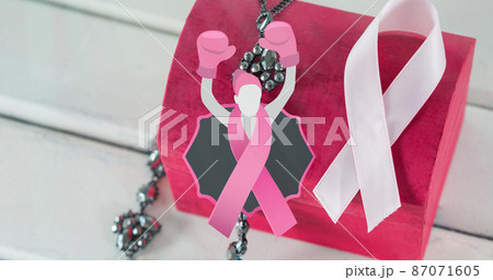 Image of woma in boxing gloves icon over pink box and ribbon on white wooden background Image of woma in boxing gloves icon over pink box and ribbon on white wooden background 87071605