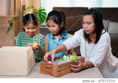 Asian mother and her daughters are decorating easter eggs preparing for Easter at home. Happy family Happy easter Happy holiday. Asian mother and her daughters are decorating easter eggs preparing for Easter at home. Happy family Happy easter Happy holiday. 87073214