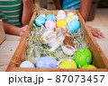 Asian siblings children are playing with baby bunny and decorating easter eggs preparing for Easter at home together with fun. Happy family Happy easter Happy holiday. 87073457