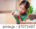 Asian child girl holding tiny bunny in hand with tenderness and love. Kid take care a pet and decorate home for Easter. Happy Easter Happy holiday. 87073487