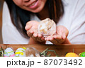 Asian woman holding tiny bunny in hand with tenderness and love. People take care a pet and decorate home for Easter. Happy Easter Happy holiday. 87073492