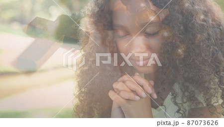 Multiple exposure of biracial elementary girl praying and rosary on bible Multiple exposure of biracial elementary girl praying and rosary on bible 87073626