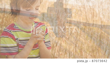 Multiple exposure of caucasian elementary boy praying with rosary on bible Multiple exposure of caucasian elementary boy praying with rosary on bible 87073642