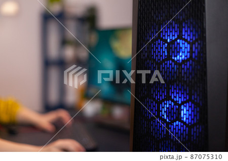 Closeup of RGB led lights powerful computer, woman gamer playing space shoother videogames 87075310
