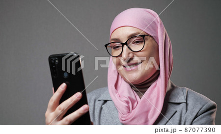 Muslim woman in hijab surfs internet social media with smile Muslim woman in hijab surfs internet social media with smile 87077390