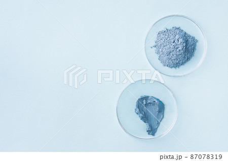 Dry facial blue clay powder in petri dishes top view. Natural organic cosmetic clay for beauty treatment. Laboratory equipment and cosmetic ingredients. Dry facial blue clay powder in petri dishes top view. Natural organic cosmetic clay for beauty treatment. Laboratory equipment and cosmetic ingredients. 87078319