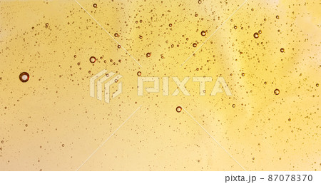Texture of oil or face serum closeup. Abstract cosmetics oil background. Texture of oil or face serum closeup. Abstract cosmetics oil background. 87078370