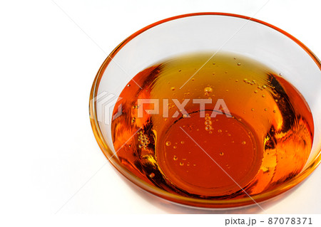 Healthy organic honey in a bowl on white background. Sweet honey healthy dessert. 87078371