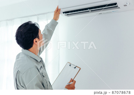 エアコン・空調設備のチェックをする作業着の男性(後ろ姿) エアコン・空調設備のチェックをする作業着の男性(後ろ姿) 87078678