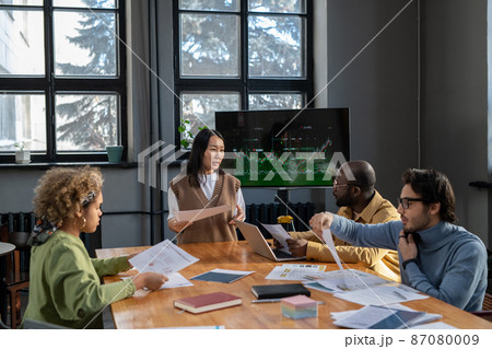 Young Asian female economist with document making presentation Young Asian female economist with document making presentation 87080009