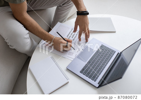 Hands of young economist with pen pointing at financial document Hands of young economist with pen pointing at financial document 87080072