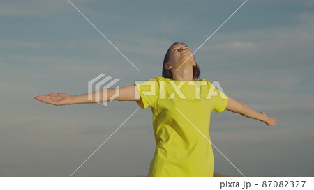 young girl background blue sky enjoys journey. happy girl day. teenage dream freedom. ask for forgiveness from heaven. man faith heaven. female meditation outdoor. stretch out hands goodness outside. 87082327