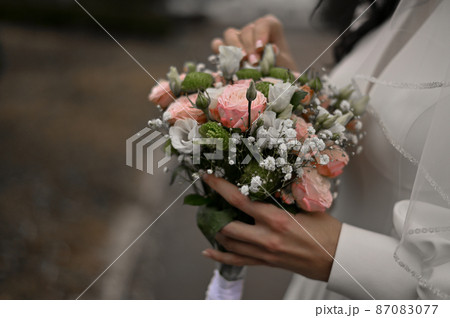 a beautiful wedding bouquet in the hands of the bride 87083077