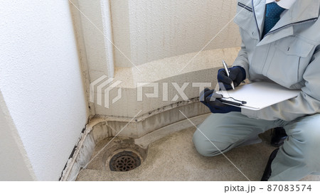 外壁の劣化・排水口の詰まりを点検する作業員 87083574