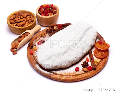 Traditional Christmas stollen cake with marzipan and dried fruit isolated on white background Traditional Christmas stollen cake with marzipan and dried fruit isolated on white background 87084213
