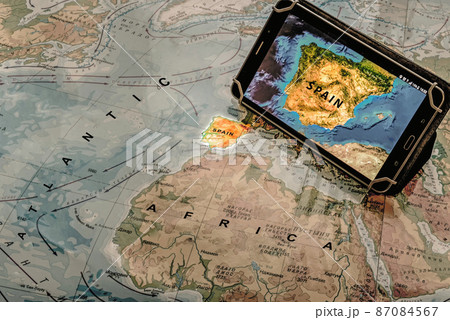 Map of Spain on tablet standing on paper geographical map. Concept of travel. 87084567