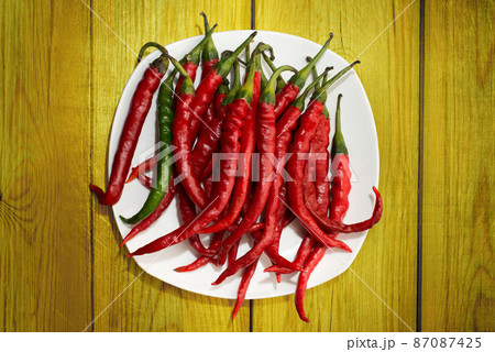 Red hot chili pepper on yellow wood Red hot chili pepper on yellow wood 87087425
